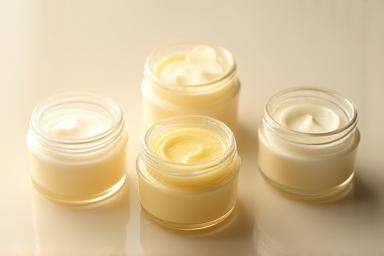 Small, elegant jars of natural lotion and balm, highlighting texture and packaging